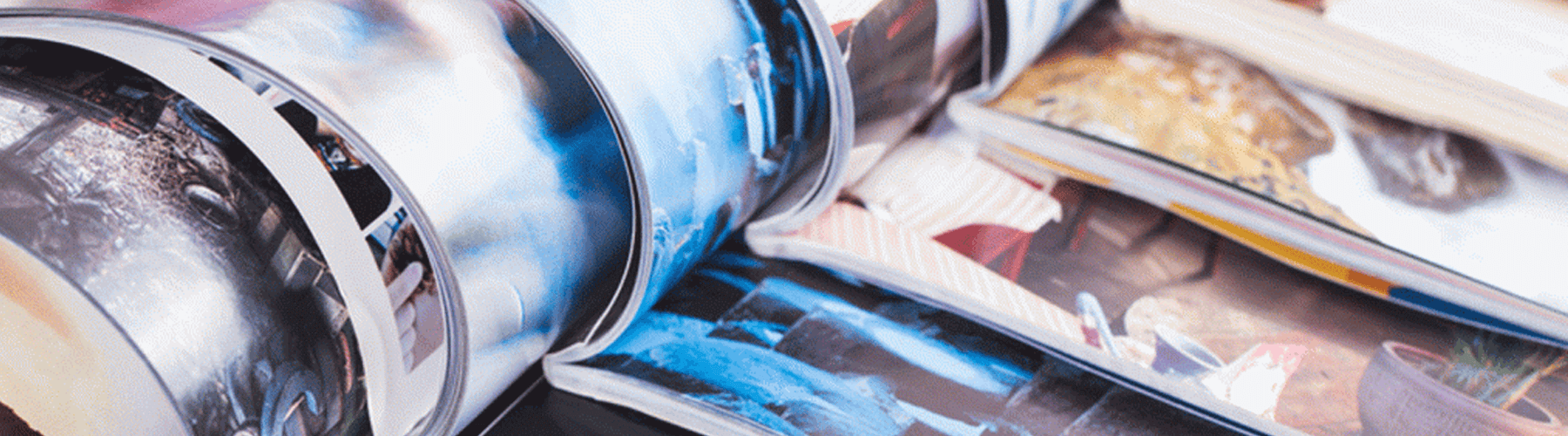 Zeitschriften und Magazine, die aufgeschlagen ineinander gereiht liegen.